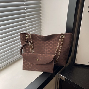 Brown letter print tote bag with gold chain straps and matching pouch in a chic room setting