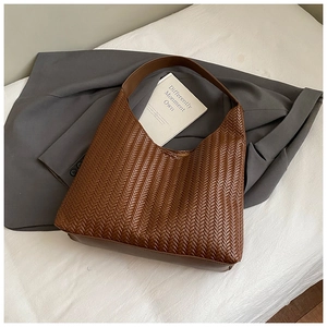 Detail shot of brown woven leather texture on a stylish tote bag for daily commute