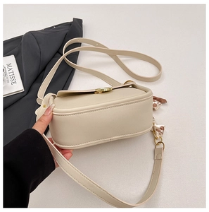 Detail of cream beige PU leather crossbody bag with gold round buckle and silk scarf