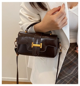 Détail du sac à main vintage en cuir ciré marron foncé avec boucle en métal doré