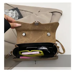 Detail showing the internal storage capacity of the brown retro textured crossbody bag