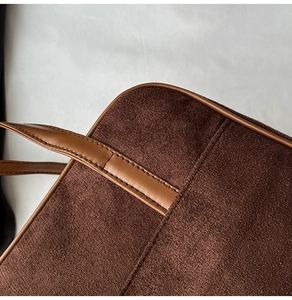 Detailed close-up of dark brown suede texture and leather stitching on retro hobo bag
