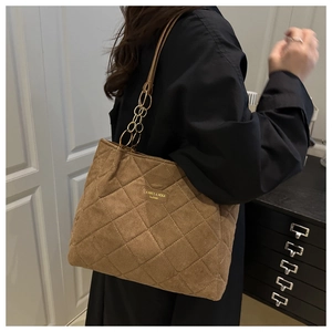 Detail der braunen gesteppten Wildleder-Tote Bag mit goldener Kette und großem Volumen