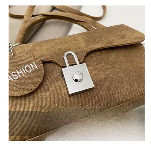 Close-up of the brown twill fabric shoulder bag with a silver square metal twist lock