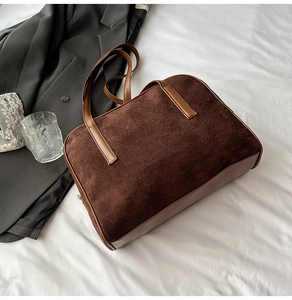 Detail of dark brown corduroy tote bag with leather straps and metal zipper closure