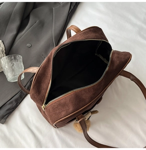 Macro view of a large capacity brown frosted suede tote bag with stylish plush ball charm