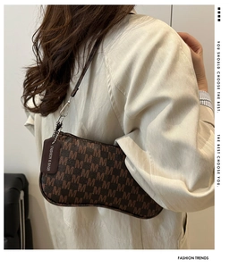 Close-up of the vintage brown monogram crescent bag featuring a fashion leather tag