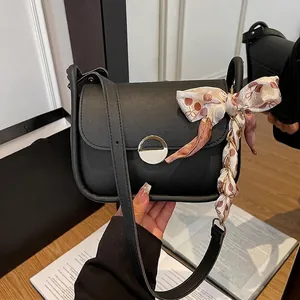 Fashionable black leather crossbody bag with silk floral ribbon and metal chain handle