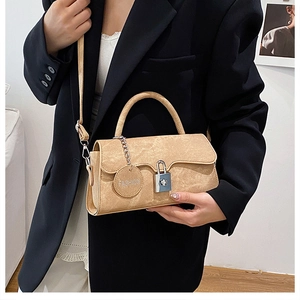 Detail of camel faux suede crossbody bag with metal chain and fashion brand tag
