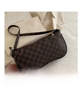 Detailed macro view of dark brown leather baguette bag with repeated letter M patterns
