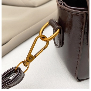 Détail de la boucle en bronze vintage et texture cuir huilé d'un sac à main marron