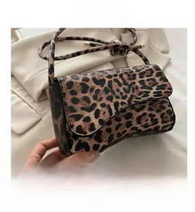 Close-up of leopard print shoulder bag with curved base and metal buckle detail