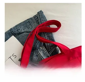 Detail of red canvas tote bag with reinforced wide handles and durable stitching