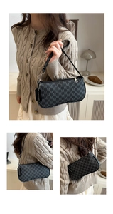 Detail of black baguette bag with letter M print, silver zipper and removable strap