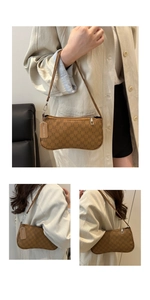 Detail view of brown monogram crescent bag featuring silver zipper and leather brand tag