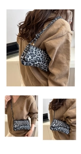 Detail showing retro black and white leopard print crossbody bag with slim shoulder strap