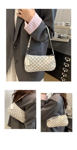 Detail of monogram print shoulder bag with fashion tag and cream slim shoulder strap