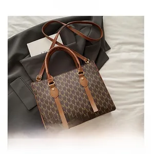 Close-up of vintage brown tote bag with M-pattern monogram and gold-tone hardware