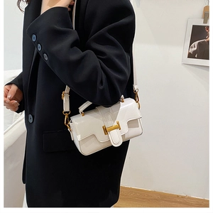 Détail d'un sac carré en cuir blanc avec une boucle métallique dorée en forme de H