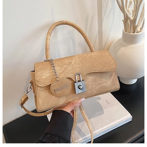 Detail of khaki faux suede handbag with wavy flap design and silver twist lock closure
