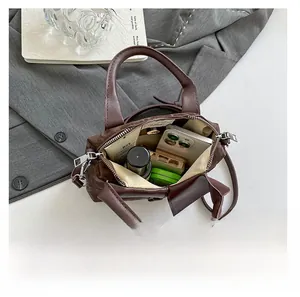 Top view of dark brown faux crocodile handbag showing interior space for essentials