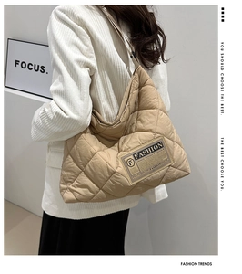 Gros plan d'un sac fourre-tout matelassé beige avec motif en losange et étiquette