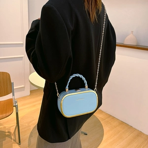 Sac à main boîte bleu clair avec cadre doré, poignée tressée et bandoulière chaîne