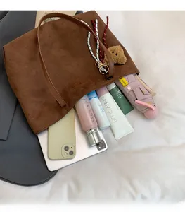Large dark brown tote bag showing internal capacity with laptop and daily essentials