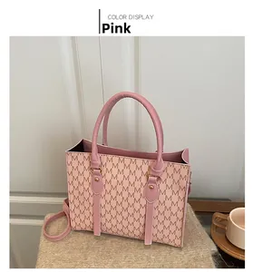 Detail of pink tote bag with M-letter print, sturdy handles and slim shoulder strap