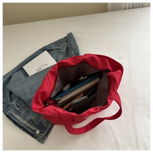 Macro detail of large red tote bag interior with spacious storage and secure zipper
