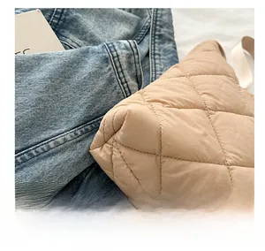 Gros plan sur le sac fourre-tout beige matelassé montrant les coutures et les losanges