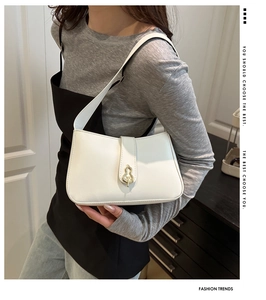 Détail du sac bandoulière en cuir blanc avec boucle métallique dorée en forme de gourde