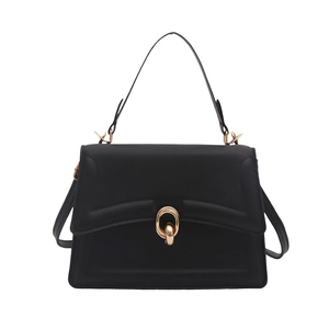 Minimalist black matte trapezoid handbag with gold double-ring clasp and shoulder strap
