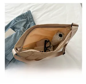 Vue intérieure du sac cabas beige matelassé avec espace pour téléphone et accessoires