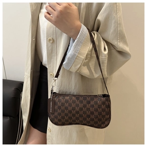 Detail of retro brown shoulder bag with monogram print and fashion decorative tag