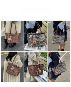 Detailed outdoor view of leopard print tote bags with brown straps and cute bear charm