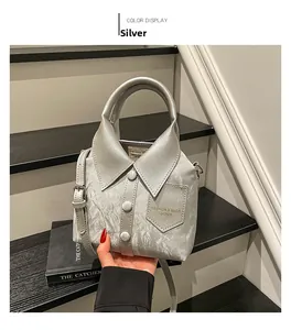 Detailed macro of silver shirt-collar handbag with metallic crinkle texture and buttons