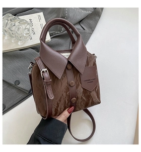 Détail du sac à main marron en cuir avec design col de chemise créatif et boutons