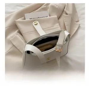 Detail showing internal capacity of the white leather crossbody bag with a wallet and phone