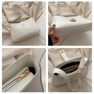 Detail view of white crescent shoulder bag showing gold hardware and inner compartments