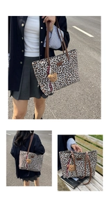 Detail of leopard print tote bag featuring brown leather straps and a plush bear charm