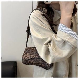 Dettaglio laterale della borsa vintage leopardata con patta e tracolla sottile