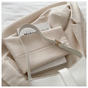 Détail du sac sous le bras blanc minimaliste avec boucle dorée et similicuir lisse de qualité