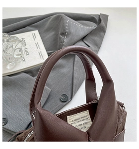 Gros plan détaillé du sac cabas en cuir marron foncé avec étiquette inspirante