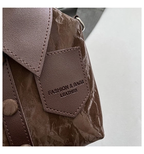 Détail du sac à main marron foncé avec cuir texturé froissé et design de col élégant