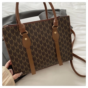 Detail of classic brown monogram tote bag with double handles and crossbody strap