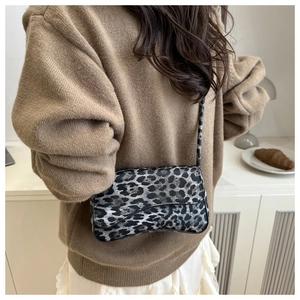 Elegante borsa sottobraccio leopardata abbinata a maglione marrone e gonna lunga