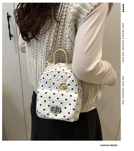 Détail du mini sac à dos blanc à pois avec broderie burger et chaîne en argent