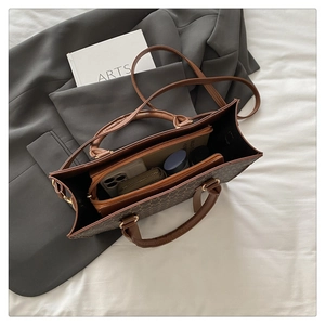 Macro shot showing internal capacity of brown tote bag with phone and wallet inside