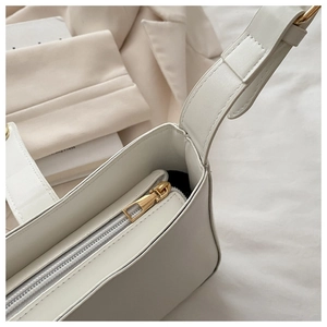 Gros plan du sac beige avec fermeture éclair dorée et texture en cuir de qualité